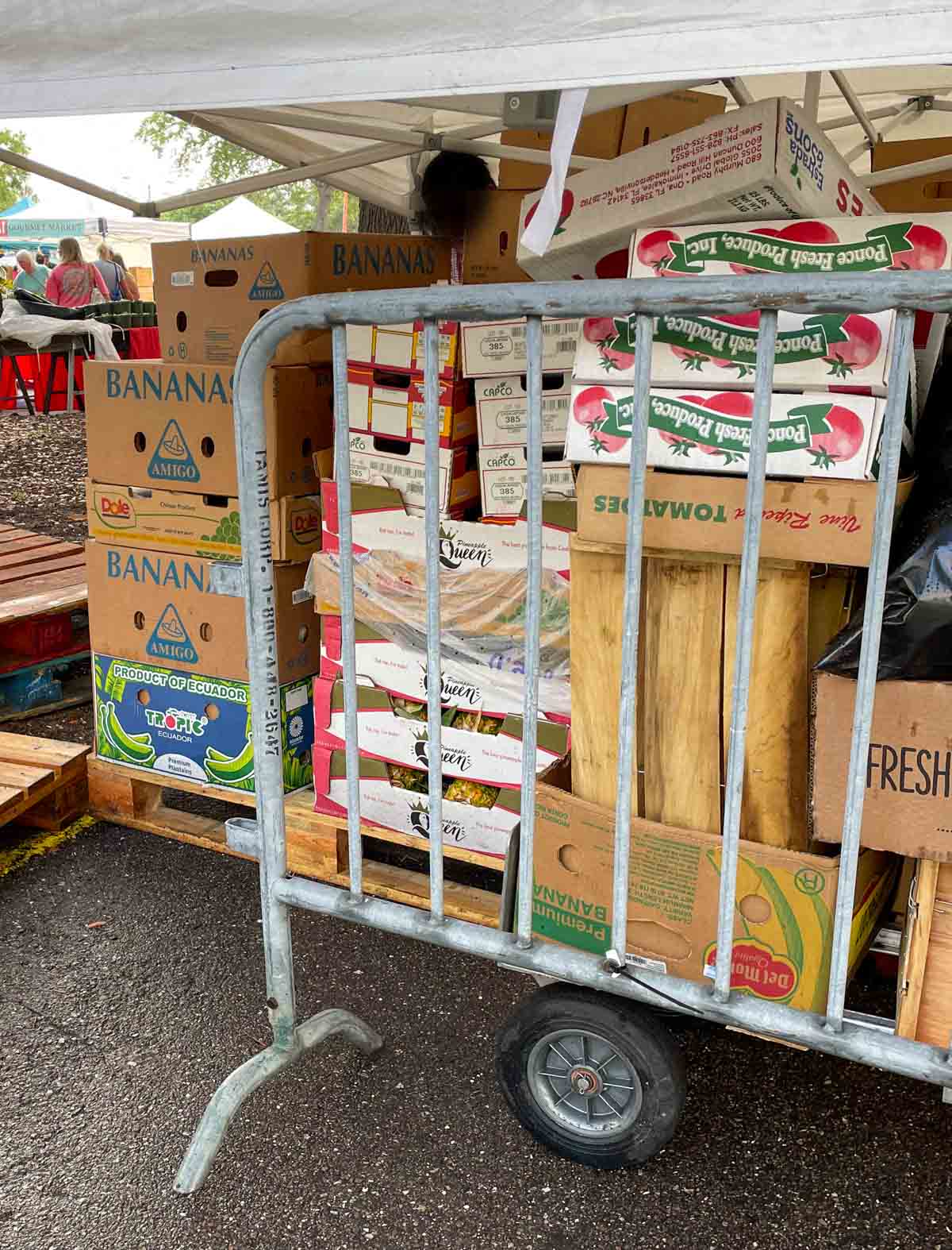 Pile of discarded boxes at a farmers market stand.