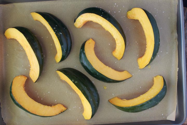 Acorn squash cut into wedges and ready to roast