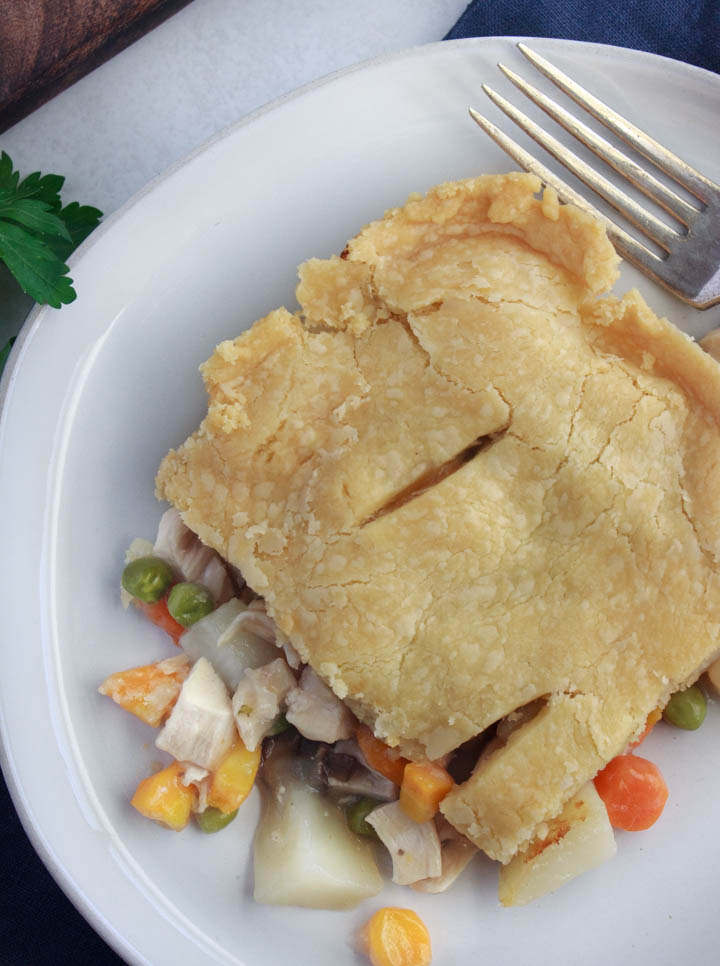 Chicken pot pie with homemade gluten-free crust on a plate, ready to eat.