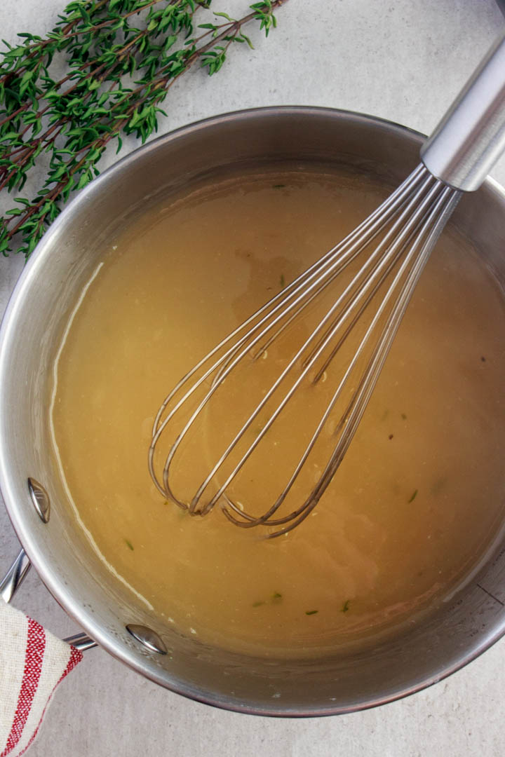 Homemade gravy being whisked in a pot