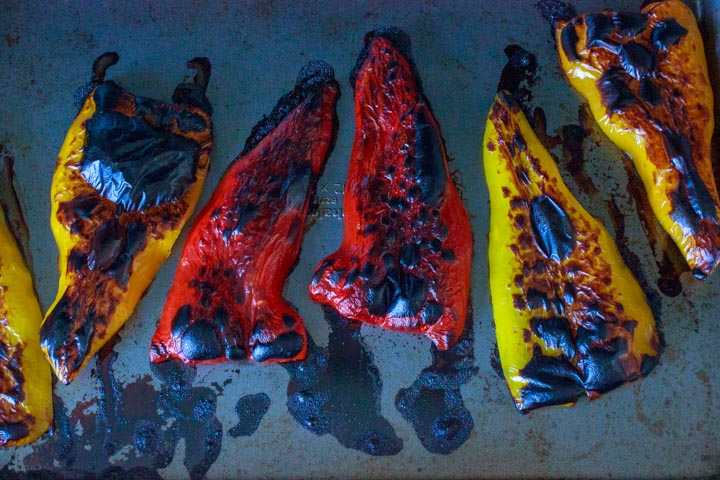 Sweet peppers charred on a baking pan.