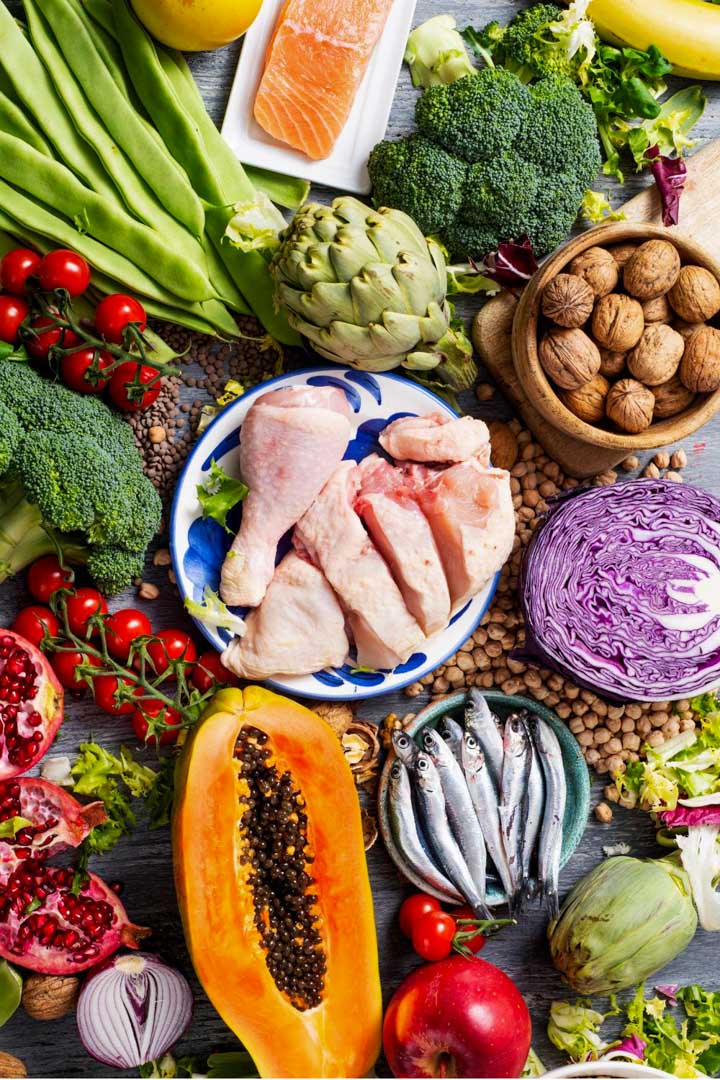 Photo of an assortment of whole foods such as fish, meat, vegetables, fruit and nuts