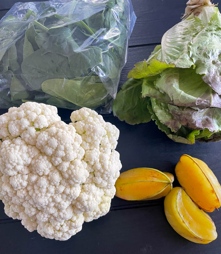 Small farmers market haul: spinach, lettuce, cauliflower, starfruit.