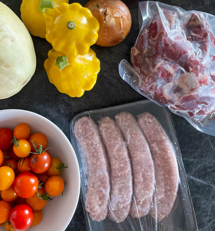 Farmers market finds: lamb, sausage, tomatoes, squash.