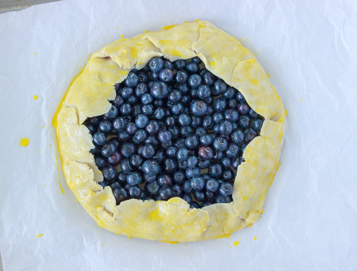 Assembled gluten-free blueberry galette with egg wash on the crust