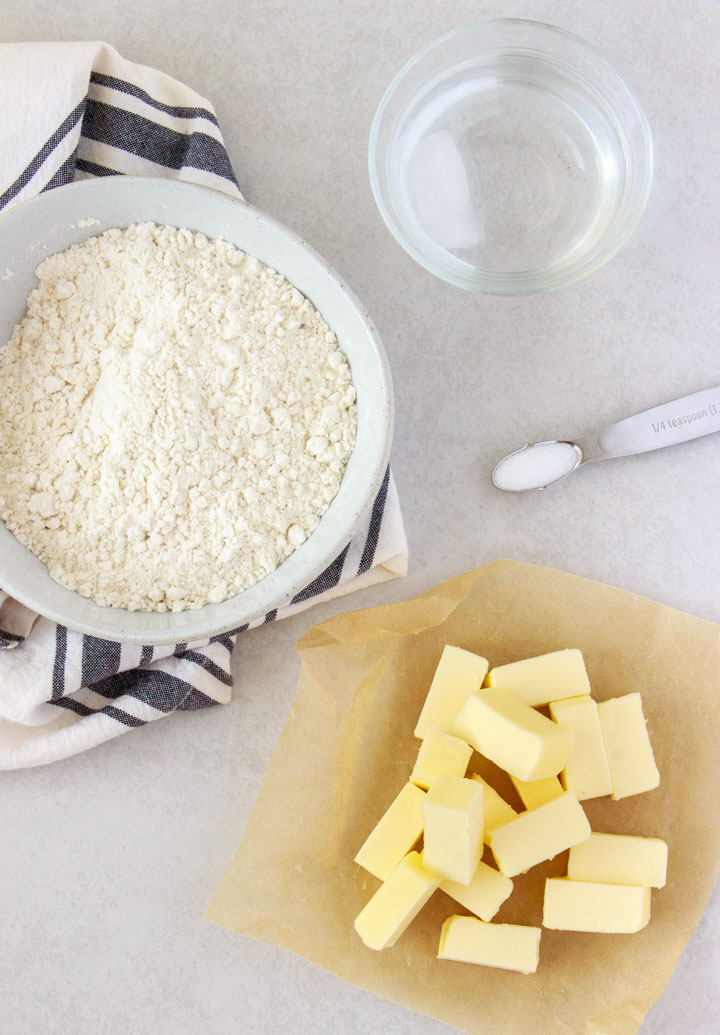 Ingredients to make gluten-free pie crust: gluten-free flour blend, ice water, salt and butter.