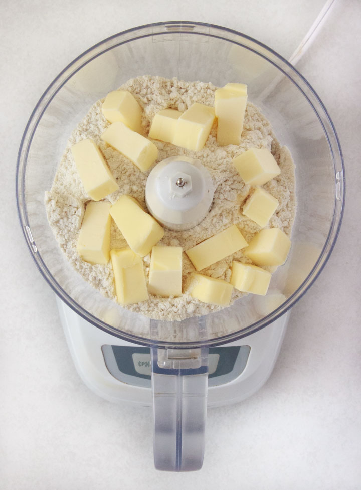 Ingredients for gluten-free pie crust in a food processor: gf flour and butter