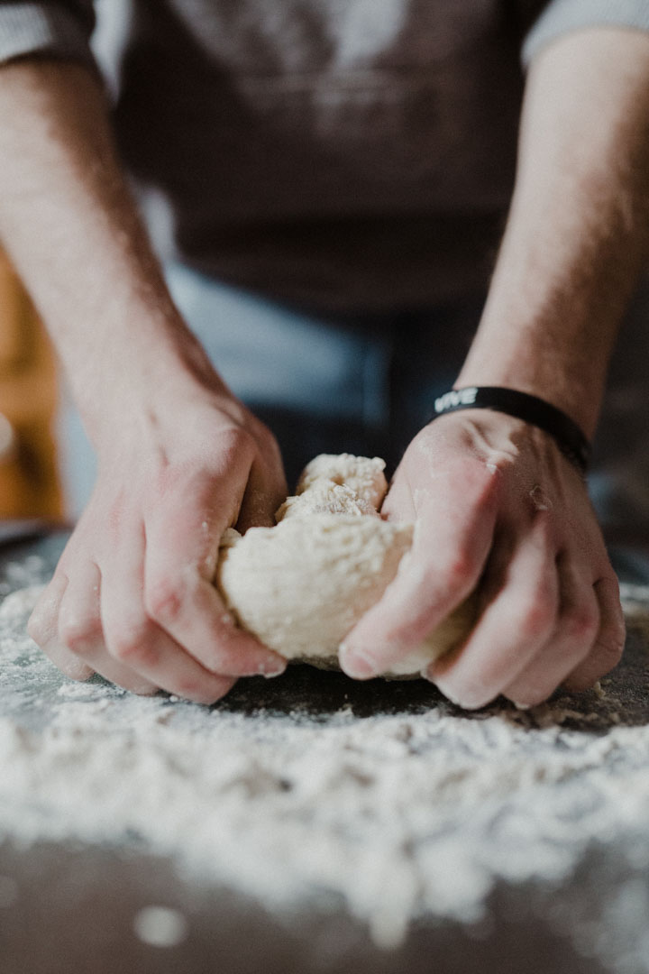 Baker kneading bread dough by hand