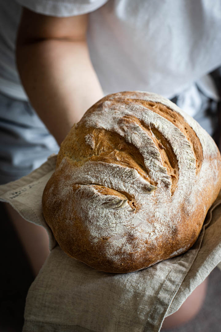 Child holding a loaf of artisan bread