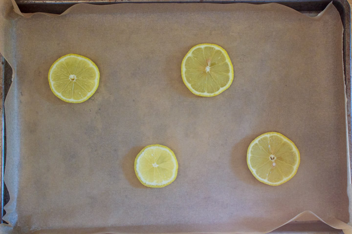 Easy One Pan Lemon Chicken Drumsticks and Potatoes - Step 1: Sheet pan with sliced lemon