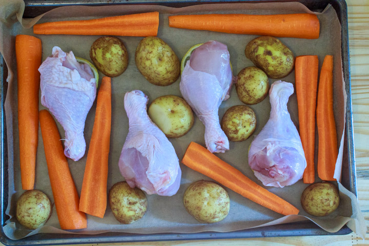 Easy One Pan Lemon Chicken Drumsticks and Potatoes - Step 3: Sheet pan with chicken drumsticks and potatoes and carrots