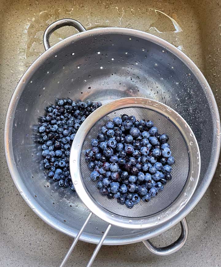 Rinsing blueberries in a colander